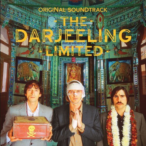 The image presents the album cover for "The Darjeeling Limited," which is labelled as a soundtrack. It features three men standing in front of an ornate building or room, each representing different members of the all-male band. The man in the center is adorned with a traditional Darjeeling cloth and is holding a small, ornate box, possibly symbolizing the theme of the album or the band's identity. The overall layout is symmetrical around the three men, with the richly decorated backdrop emphasizing the cultural context of the album. The texts are arranged in such a way that they draw attention to the album's title and theme.