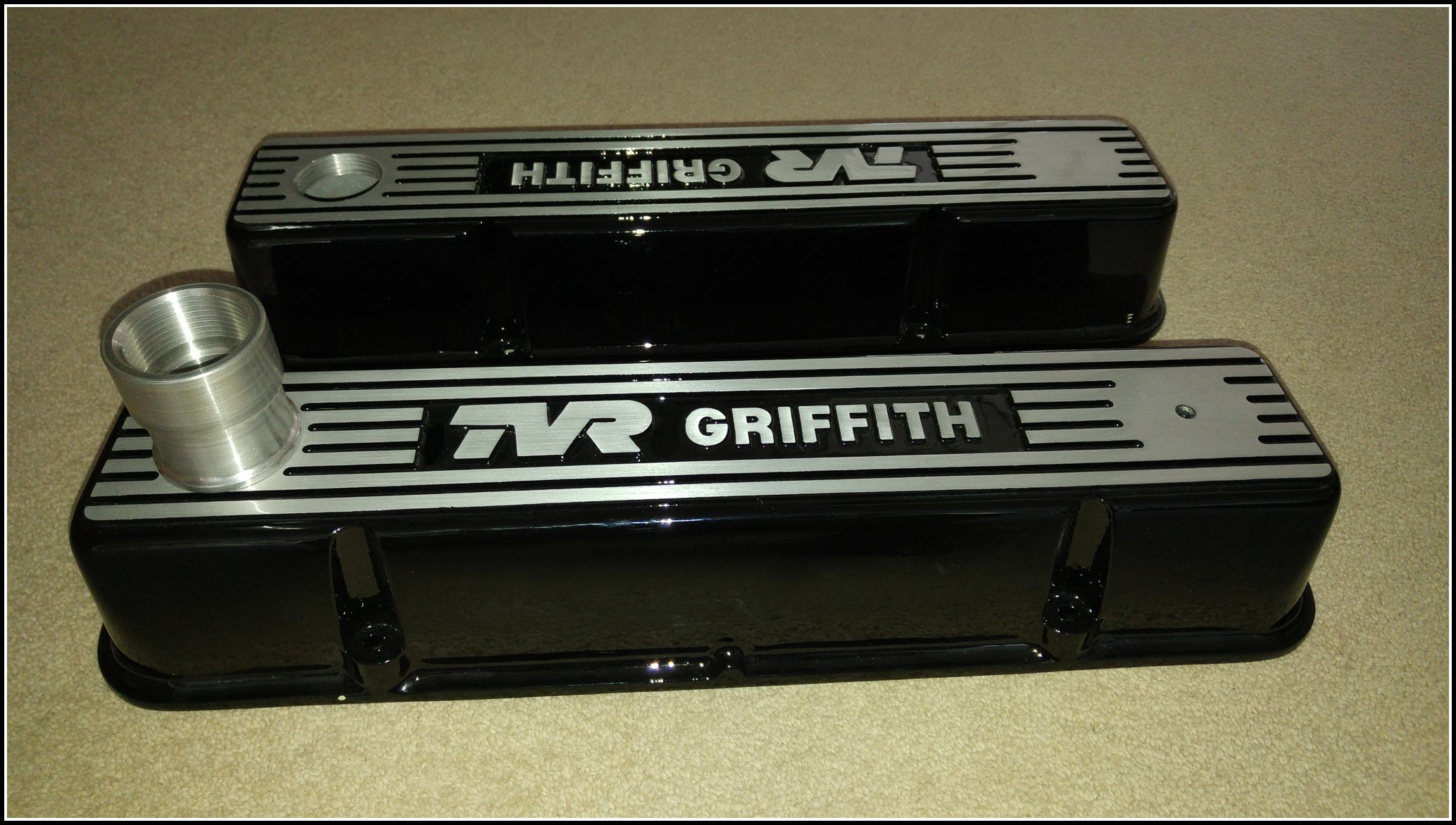 rocker covers - Page 1 - Griffith - PistonHeads - The image shows two different ashtrays with a finish that appears to be pebble-like granite. One of the ashtrays has the text "Twin Peak" in bold white letters, while the other reads "RANI GRIFFITH." The ashtrays have a sectioned off to hold the ashes, and there is a visible cylindrical silver component extending over one of the ashtrays. They are placed on a flat surface, likely for presentation or use.