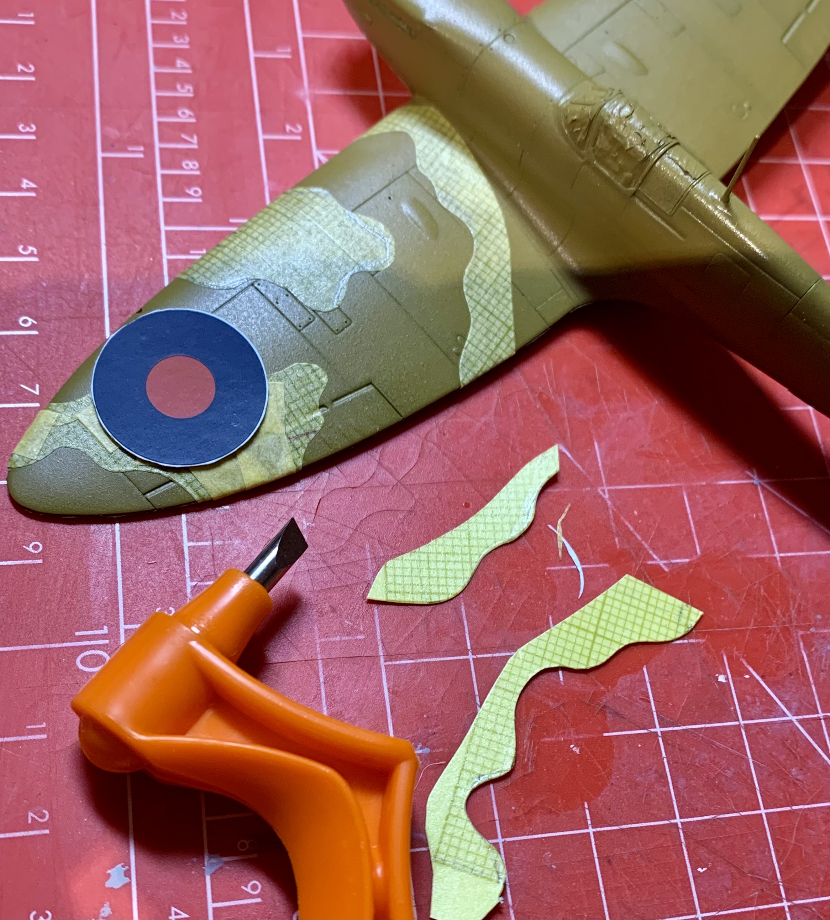 Pistonheads - The image features a model of an airplane, which appears to be a British World War II aircraft. The plane is predominantly brown and green, with yellow markings that suggest it's a toy or a kit designed for assembling model planes. There's a pair of scissors placed next to the plane, possibly used in the assembly process. Additionally, there are small pieces of paper attached to the airplane with what looks like blue and red stickers, indicating the plane may be undergoing some customization or modification. The scene is set against a backdrop that suggests it's been captured on a table or work surface.