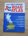 Pistonheads Cockpitsatnav Update - The image shows a book lying on a surface. The book has a horizontal orientation and the cover is of a photography style, displaying a two-toned blue color with white text. The title of the book is displayed prominently in large, bold letters, reading "great britain road atlas". Below the title, the text is smaller and lists the various countries that are included in the atlas. The spine of the book is visible and repeats the title of the book, suggesting that it is a popular or standard publication. The overall style of the book suggests it is a functional and informational publication for travel.