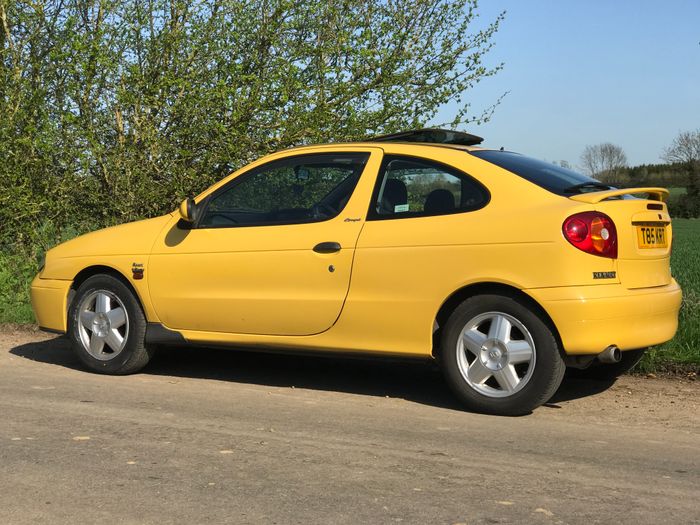 A yellow car is parked in a parking lot - Pistonheads