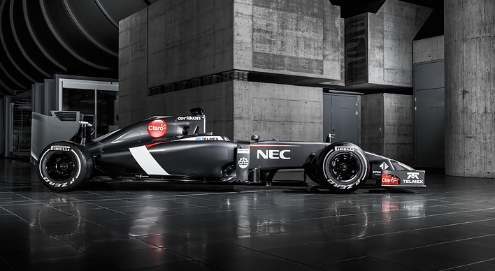 Sauber C23 revealed... - Page 1 - Formula 1 - PistonHeads - This image depicts a modern Formula-E racing car parked in an indoor setting, featuring a distinctive black and white livery with sponsor logos such as NEC. The car is positioned on a reflective floor, which mirrors its form, creating an interesting visual effect. The background includes a gray structural framework, adding a stark contrast to the sleek and colorful vehicle. The overall ambiance suggests a professional environment, possibly a race workshop or a testing facility for professional race car drivers.