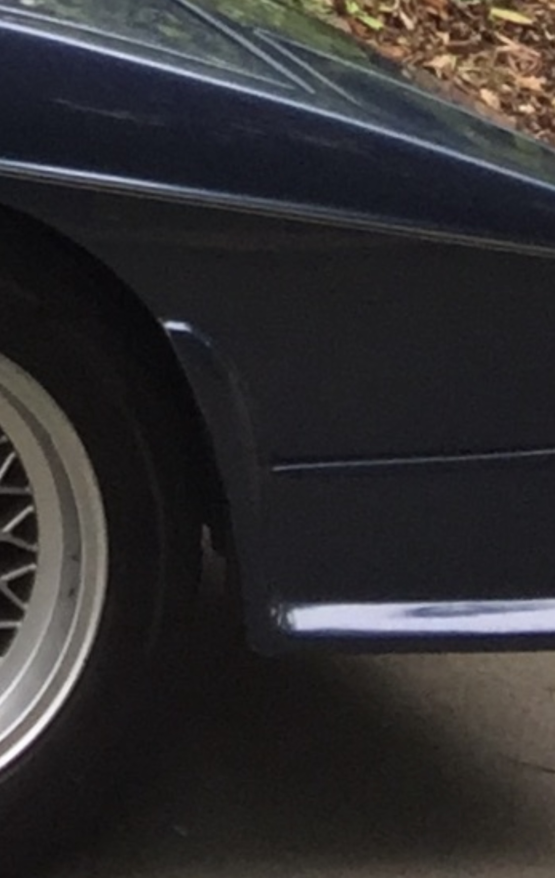 Pistonheads - The image is a split-frame photograph of a blue car. On the left side, there's a close-up of a tire on the car with a shiny hubcap and silver rims. On the right side, the same car is shown from a distance, capturing its sleek design and the metallic sheen on its body. The car appears to be parked outdoors.