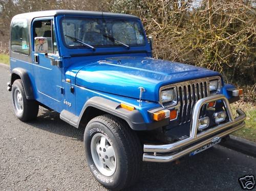 my new Jeep - Page 1 - Off Road - PistonHeads - The image shows a vintage blue jeep parked on the side of a road during what appears to be daytime. The vehicle's hood is slightly raised and features a white emblem on the side, consistent with a specific brand. The gazelle logo, indicating that it's a Swedish car, is also visible. The jeep is positioned in front of a section of grass with some bare branches, suggesting a natural or rural setting. The focus of the image is on the vehicle, providing a clear view of the front, hood, and part of the side.