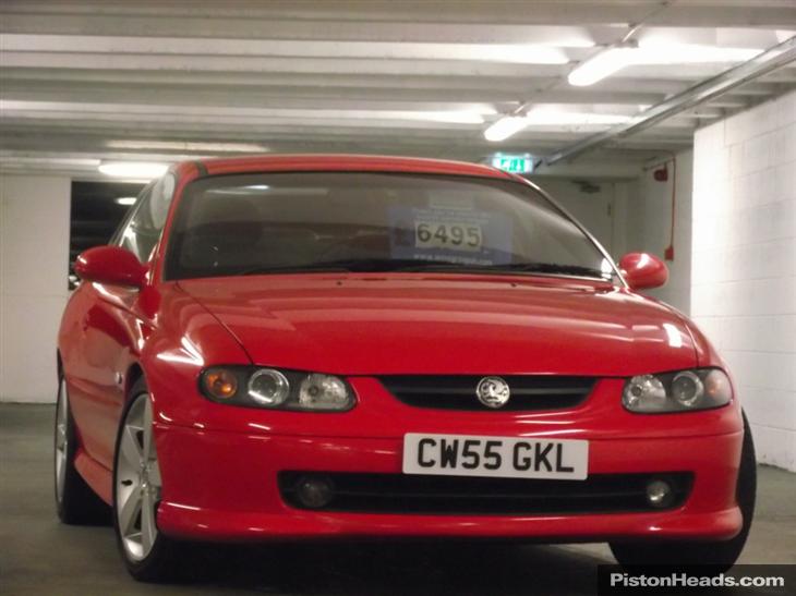 These pictures make my teeth itch - Page 10 - The Lounge - PistonHeads - The image shows a shiny red car parked in a garage. The vehicle is sleek and features a European license plate, indicating it might be from a European country. The garage itself is spacious and well-lit, with a white wall visible in the background. The overall impression is of a clean and well-maintained environment for the car.