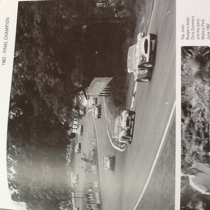 Ebay Grantura - Page 1 - Classics - PistonHeads - The image is a black and white photograph presented in a similar style to a newspaper layout. It depicts a vintage scene of multiple cars racing each other on a race track. The perspective of the photo is from the side of the track, capturing the vehicles in mid-race as they navigate curves and obstacles. The image is marked with text at the top that reads "1922 FINAL CHAMPION," indicating the nature of the event, and at the bottom with additional text, although the content of the text is not discernible from the provided image. The overall style of the photograph evokes a sense of nostalgia and historical significance.