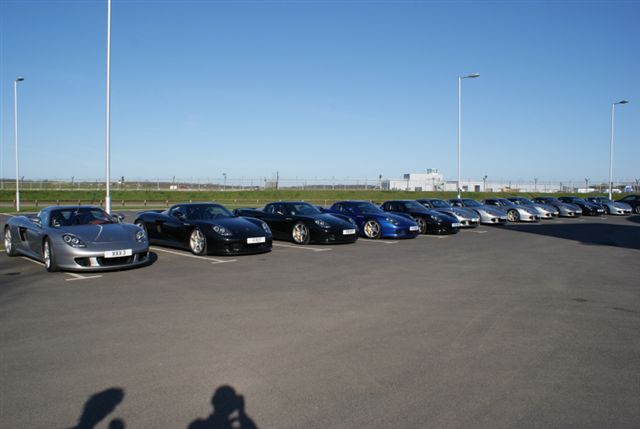 Pistonheads - The image showcases a parking lot filled with a diverse array of luxury cars. Each car has its unique color and model, parked neatly in rows. The lot is situated in the daytime under a clear blue sky, possibly in a city or an upscale neighborhood. The perspective is captured from the parking lot, providing a broad view of the parking area and vehicles within it.