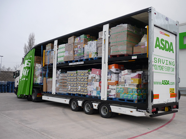 So, what exactly do you do then? - Page 1 - Commercial Break - PistonHeads - This image depicts an Asda lorry parked on an asphalt surface. The truck is completely loaded with various goods, having multiple shelves stocked with goods. The side of the lorry features bold lettering advertising Asda and its slogan "Saving you money every day," along with the since-discontinued online address asda.com. The weather appears to be overcast with cloudy skies. Surrounding the truck, there are other vehicles and structures, as well as natural light suggesting it may be day time.