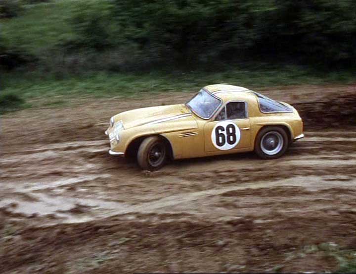 Early TVR Pictures - Page 36 - Classics - PistonHeads - In the image, a vintage racing car is the main focus, sitting on a dirt road. The car is a Porsche, identifiable by its distinct design and the number '68' emblazoned on its side. The backdrop includes a grassy area and what appears to be a shallow mud or water pit, suggesting the car may have been racing or testing. The vintage feel of the car and its setting gives a sense of nostalgia and adventure.