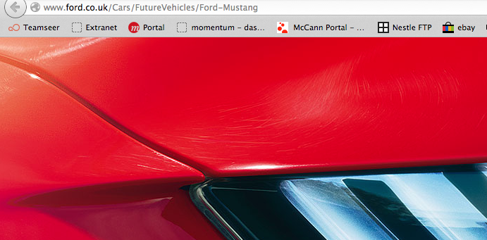 So who has ordered the new S550 Mustang? - Page 10 - Mustangs - PistonHeads - The image displays a sleek, close-up view of the front of a red, high-performance sports car. The exterior of the car shows a glossy finish with a shiny cut-line and car headlamps. The background features the website address "www.FORD.co.uk/Cars/Future-vehicles/Ford-Mustang" with other car-related tabs and buttons visible. The website likely pertains to the description or purchase of automobiles, as indicated by the links and categories for different car options and brands.