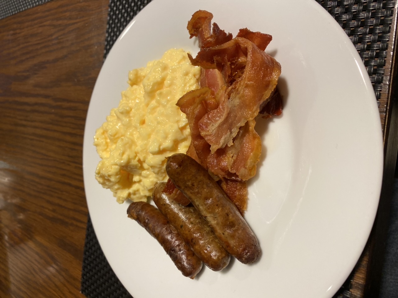 The Great Breakfast photo thread - Page 350 - Food, Drink & Restaurants - PistonHeads - The image presents a hearty breakfast meal served on a white plate. On the left side of the plate, there's a stack of crispy bacon slices. To the right, there's a serving of scrambled eggs that appear fluffy and cooked to perfection. Complementing this protein-rich meal is a small bowl filled with what seems to be creamy mashed potatoes on the left side. On the top right corner of the plate, a sausage links the two main components of the meal: bacon and eggs. The overall presentation suggests a delicious and satisfying breakfast choice.