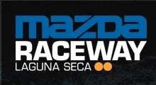 Respraying the Mk1 - what colour? - Page 1 - Mazda MX5/Eunos/Miata - PistonHeads - The image is a graphic design with a black background. It features the text "MAZDA RACEWAY LAGUNA SECA" in prominent white and blue fonts. The first word, "MAZDA," is in large, bold letters, followed by the word "RACEWAY" in a smaller but still bold font. The third word, "LAGUNA SECA," is in a large, bold font, while "MAZDA" and "LAGUNA SECA" are on separate lines. Between the words "MAZDA" and "RACEWAY" are arrows pointing upwards, and between the words "RACEWAY" and "LAGUNA SECA", there is a stylized starburst motif. The overall style of the image is sleek and modern, suggesting a racing or automotive theme.