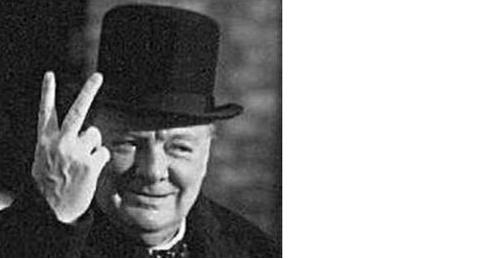 Pistonheads Brown Salute - The image is a black and white photograph. It features an elderly male with a friendly smile. He is wearing a black top hat and a dark overcoat. The man is flashing the peace sign, a gesture commonly made with the index and middle fingers. He appears to be outdoors, with shadows hinting at lighting from the left side.