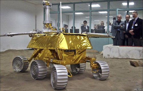 A truck with a tarp on the back of it - Pistonheads - The image portrays a gleaming, gold-plated robotic vehicle stationed indoors. The robot is situated in a large white space, surrounded by a group of individuals. Their expressions range from interest to casual conversation. The overall setting seems to be some sort of exhibition or showroom where the robot is being exhibited or repaired. The room appears well-lit and spacious, providing a stark contrast to the metal exterior of the gold robot.