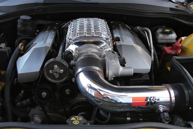 A close up of a motorcycle parked on a street - Pistonheads - The image provides a close-up view of the underside of a vehicle's hood, showcasing the engine and its metallic components. An up-close view reveals the intricate details of the engine components, such as the intake manifold and cylinder heads. A distinctive feature visible in this shot is a chrome manifold, which adds a reflective element to the image. This type of photograph is often taken in the context of car showcases, to appreciate the design and craftsmanship that goes into an engine.