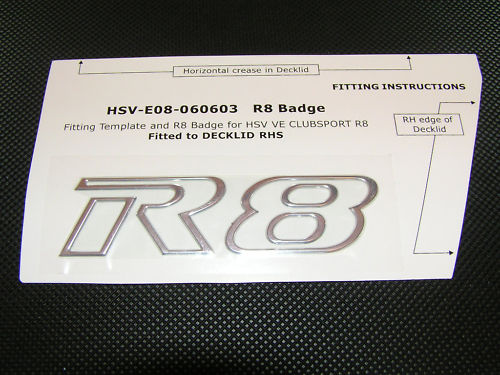 HSV Cubsport  R8 badge wanted - Page 1 - Australia - PistonHeads - The image displays a blank, metallic-looking badge template with the text "HGV E&O 060603" printed on it, indicating the type of badge. There are two lines of text suggesting different fitting instructions, one for the clubport R8 found at the top of the badge, and another for the Decklid RHS at the bottom. The badge is hexagonal, with the letters "HG" prominently positioned at the center, and it features raised numbers "888". The template appears to be attached or fixed over a gray background.