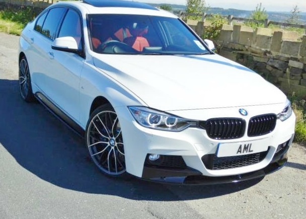 BMW F30 335d XDrive M-Sport leasing Deals - Page 1 - BMW General - PistonHeads - This is a photograph of a white BMW car driving down a road. The vehicle features the automaker's distinctive design elements, such as the famous kidney grille and triple headlights. There is a clear blue sky in the background, and a fence with stones implies a rural or semi-rural area. The car's license plate is visible, but the letters and numbers on it are not identifiable.