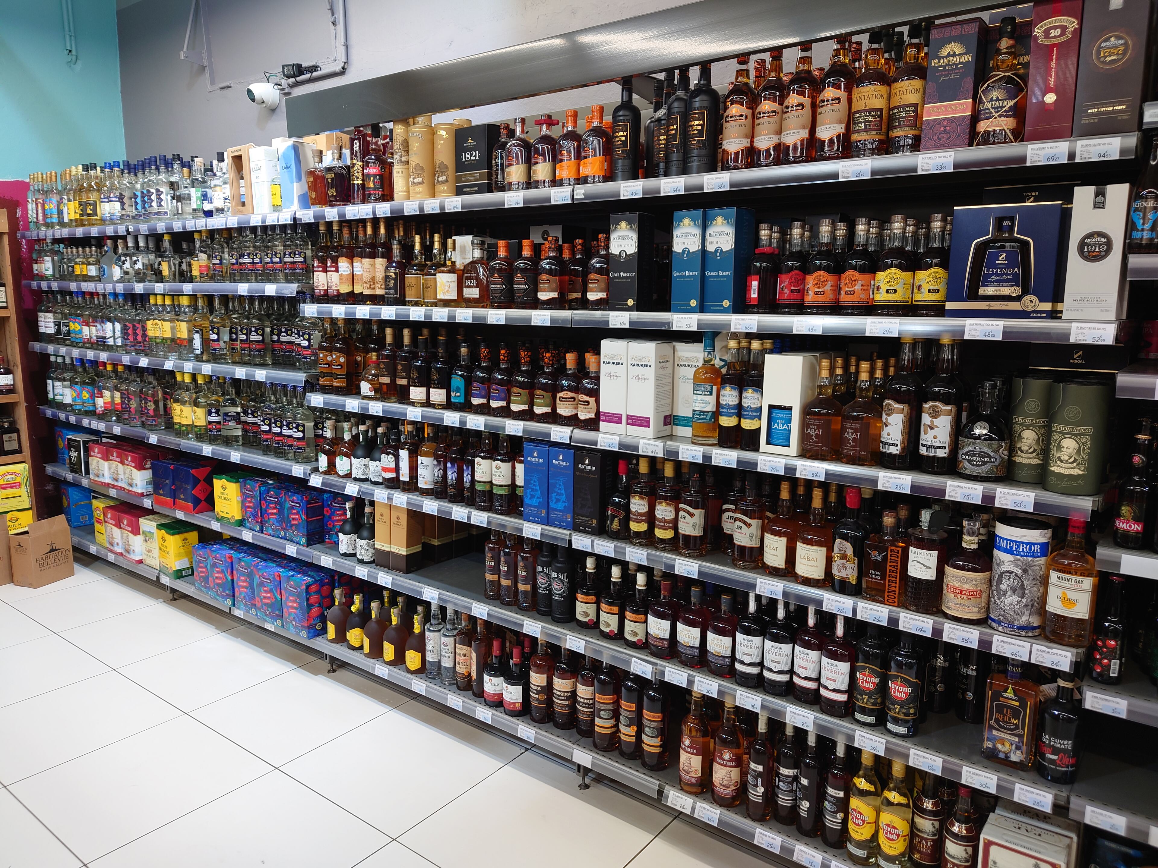 Pistonheads - The image shows a well-stocked liquor store with an array of bottles. The store is filled to the brim with various types of alcohol, including whiskey, rum, gin, and vodka. There are also several cases of beer on the shelves. The bottles are neatly arranged on multiple shelves, showcasing a diverse selection of drinks. In the background, there's a sign that reads "Sales," indicating that this is indeed a retail store for alcoholic beverages. The atmosphere appears inviting and well-organized, ready for customers to browse and make their selections.