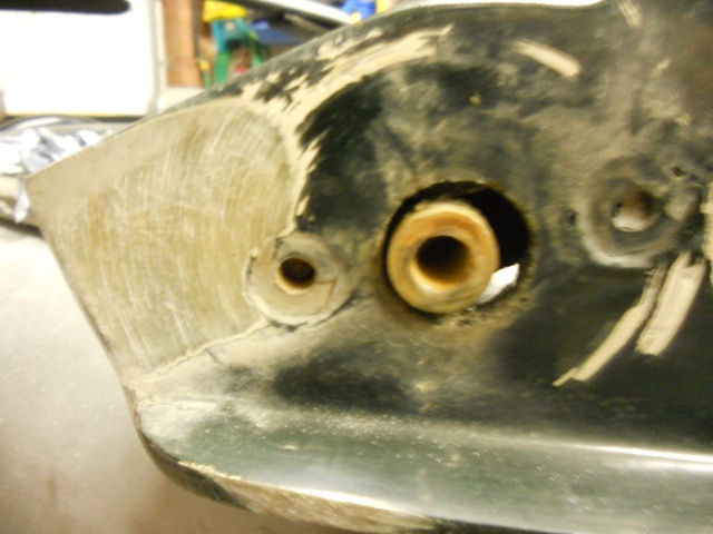 Pistonheads - The image captures a close-up view of a worn, gray motorcycle bumper. The bumper, which is likely made of plastic or metal, stands out in its worn state. The most striking feature is a large hole with two smaller holes, creating an interesting circular pattern. The bumper is placed in a garage, evident by the ghost of a white wall faintly visible in the background, suggesting a setting where vehicles are stored or worked on.