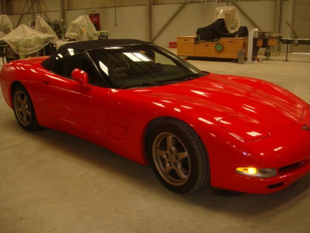 Pistonheads - The image showcases a vibrant red sports car positioned in the middle of a spacious, well-lit garage. The car's exterior is sleek and luxurious, featuring a curved design and shiny chrome accents. The interior is not visible, but the high-quality upholstery suggests comfort and style. The large circular openings in the garage allow natural light to flood the space, enhancing the car's striking color. The setting suggests a private collection or a high-end dealership.