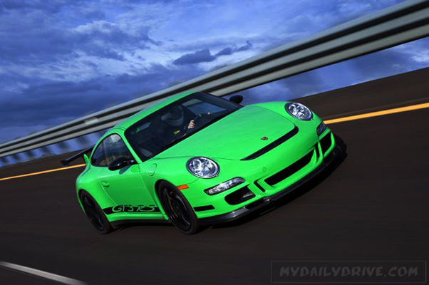 Spray Job & interior Recolour (Co Durham Area) - Page 1 - Porsche General - PistonHeads - The image displays an eye-catching green Porsche race car in mid-motion on a road. It's a sports car with a low ride height and aerodynamic styling, showcasing a striking color that makes it stand out. The setting is dynamic, with the car on a highway under an overpass. The background features a cloudy sky, adding to the intensity of the scene. There's a sense of speed and performance implied by the angle and direction of the car. The overall image has a vibrant and energetic vibe, emphasized by the contrast of the green Porsche against the darker surroundings and the road.