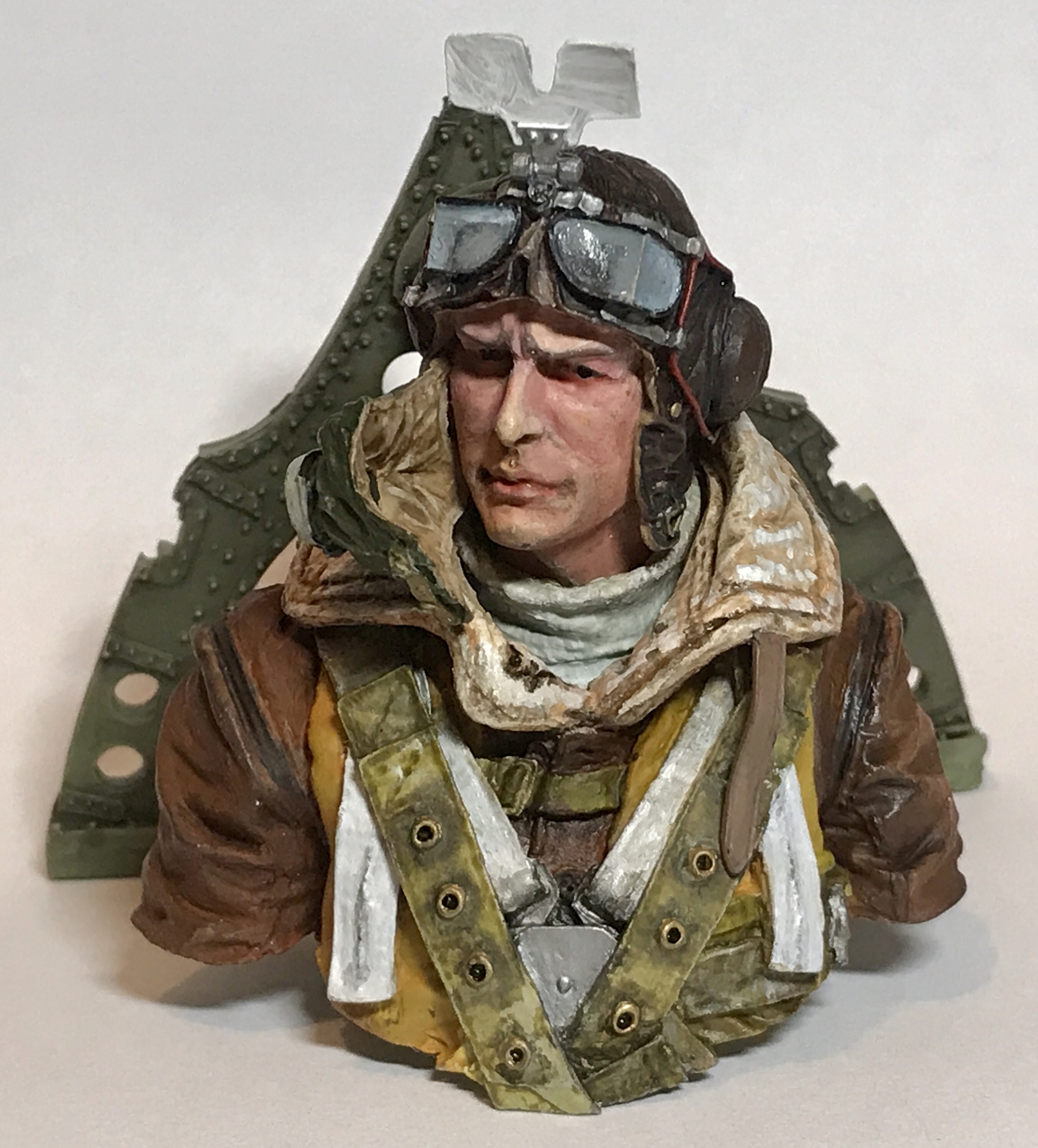 The thread where we can talk about painting figures. - Page 3 - Scale Models - PistonHeads - This image shows a figurine of an airman. The figure is depicted wearing a flight suit and flying goggles, suggesting that it represents a pilot or fighter pilot. The individual appears to be male with short hair, and the overall style of the artwork leans towards a realistic portrayal. The background of the image is neutral, emphasizing the figurine without any distractions.