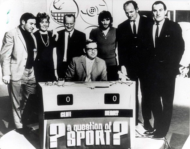 RIP Cliff Morgan - Page 1 - Sports - PistonHeads - The image appears to be a promotional photograph for the game show "A Question of Sport". It features five adult men standing behind a podium with the show's logo on it. They are wearing what suggests to be business attire, with some in suits and others in professionally appropriate outfits, fitting for a broadcast setting. The host of the show was facing the camera, engaging with the audience or participants, while the panelists are looking directly at the camera. The setting seems professional, likely in a studio or TV station control room.