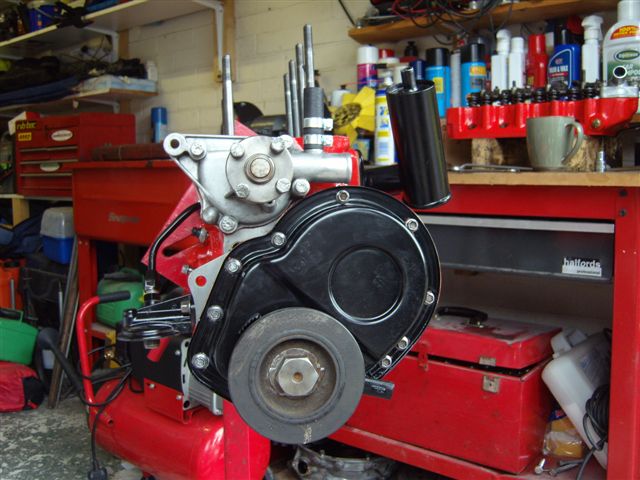 pics - Page 1 - Classic Minis - PistonHeads - The image shows a workspace with a red motorcycle jack and a matching red toolbox. The motorcycle jack is mounted on a red workbench or surface that appears to be situated in a garage or workshop. There are various bottles and other tools visible in the background. The detailing the silver-colored engine components and the red-covered base of the jack suggest that maintenance or repair work might be done on the motorcycle on this rack.