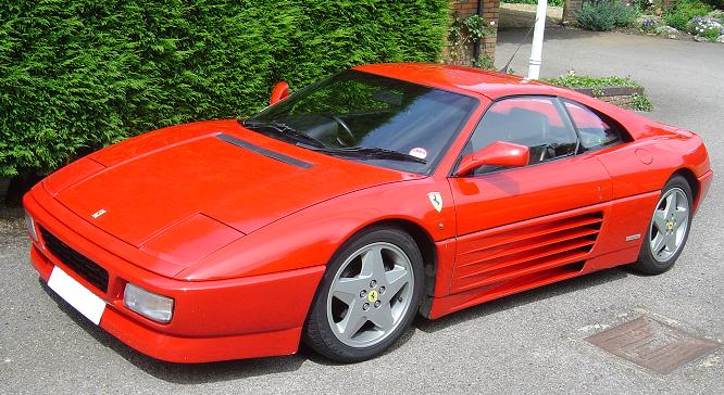 Ferrari 348 chit chat - Page 1 - Ferrari V8 - PistonHeads - In this image, a sleek red sports car is parked on a driveway. Its glass top and silver spokes add to its luxurious appearance. The vehicle, which appears to be a Ferrari, is positioned on the right side of the image. The background reveals a well-maintained lawn, bathed in the soft glow of the shrubs. Despite the presence of the car, the overall ambiance of the image suggests a peaceful suburban setting.