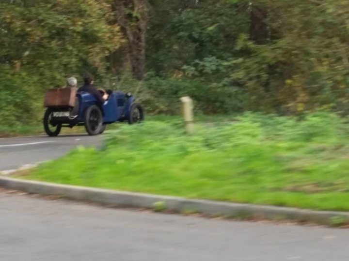 A truck driving down a road next to a forest - Pistonheads
