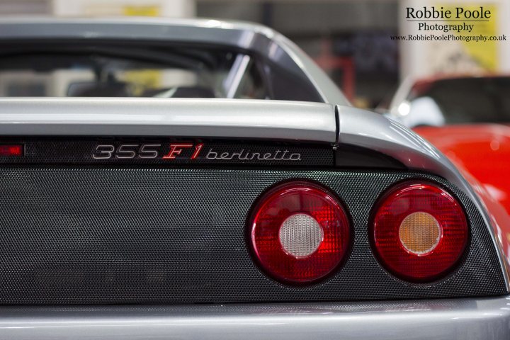 The GT Cafe - the ace cafe of the north - Sept meet - Page 1 - North West - PistonHeads - The image features a close-up view of the rear end of a sports car, with a focus on its tail lights. The car model is identified as "355 FL1 GTO," and the name "BERLINETTA" is visible on the backrest of the rear window, indicating a customization or variant of the GTO. The car is well-maintained, with a classic black and red color scheme on the exterior. In the background, another car is partially visible, suggesting that this photo may have been taken in a car show or a garage with several vehicles.