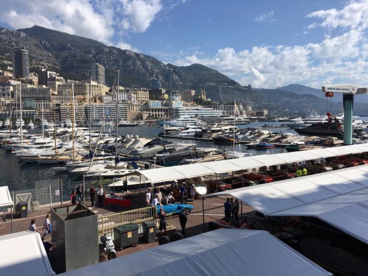 Pistonheads trip to Monaco Historique - Page 2 - Aston Martin - PistonHeads - The image presents a bustling scene at a dock in a harbor. Along the dock, various boats of different sizes are docked, contributing to a lively maritime atmosphere. The dock is lined with people, who are dispersed across the area, perhaps enjoying the view or waiting to board.

The background of the photo provides a contrast to the dock, with a vibrant cityscape adorned with the peaks of mountainous terrain. The city boasts towering buildings that stretch up to meet the sky, suggesting a bustling urban environment.

The overall atmosphere of the image suggests a dynamic meeting of nature and city life, with the dock serving as a bridge between the tranquil waters and the energetic cityscape. The presence of people, buildings, and boats creates a sense of movement and activity, inviting viewers to imagine the stories of the day unfolding in this harbor setting.