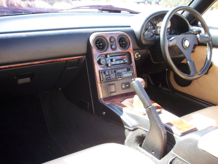 1st Trackday - Page 1 - Mazda MX5/Eunos/Miata - PistonHeads - The image captures the interior of a luxury car, focusing on the driver's side. The car's interior is predominantly black, with the dashboard being covered in wood, adding a touch of elegance. A steering wheel with silver accents is at the center, indicating a well-appointed vehicle. On the dashboard, you can see various controls and dials, suggesting advanced features. There's also a manual transmission, which is not commonly found in modern vehicles. The overall setting suggests a sense of luxury and sophistication.