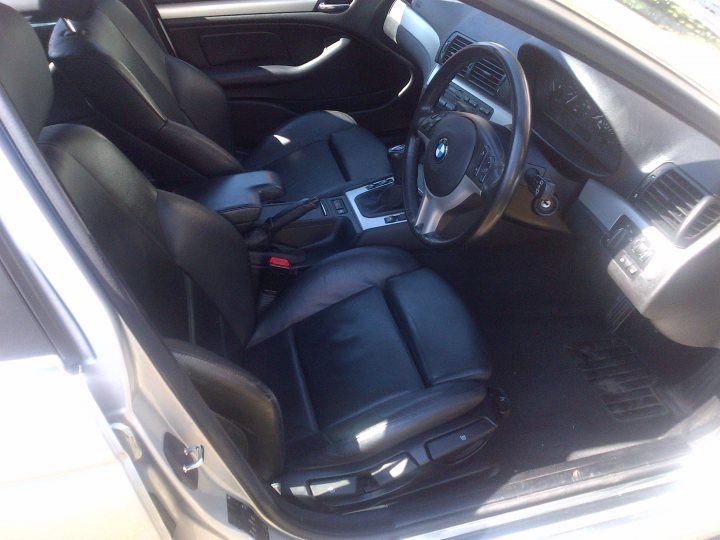 A close up of a car with a lot of luggage - Pistonheads - The image depicts the interior of a BMW car. The car is equipped with black leather seats. The steering wheel is neatly arranged in the center of the dashboard, which appears to be color black. The car seems to be a BMW 3 Series, identifiable by its distinctive logo on the glove box. The interior of the car is well maintained, indicating it may be recent or well cared for.