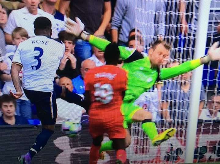 The Official Liverpool FC Thread [Vol 11] - Page 299 - Football - PistonHeads - The image captures an intense moment from a soccer match, focusing on two players in action. A man in green is leaping to block the path of a soccer ball with his body, momentarily suspended in the air with an outstretched hand. His athletic posture suggests a strong defensive play. Opposite him is another player, dressed in a red jersey, who is running towards the goal, apparent by the soccer ball in proximity. The crowd is visible in the background, absorbed in the thrilling spectacle. The image is presented in a colorful outdoor setting, emphasizing the vibrant attire of the players and the spectators.