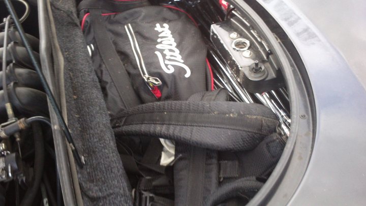 Would buying an Elise be a really stupid idea? - Page 1 - Elise/Exige/Europa/340R - PistonHeads - The image shows the trunk of a car fully open, revealing the storage compartment. Various golfing equipment is visible, including what appears to be a golf bag and possibly a golf club or chain bag. Several tools, such as a wrench with a red grip and a screwdriver with a silver handle, are stored in the compartment, suggesting that the car is used for a variety of purposes including golf and possibly a business that requires tools. The items are placed in an organized manner, likely to make the most use of the limited space available in the trunk.