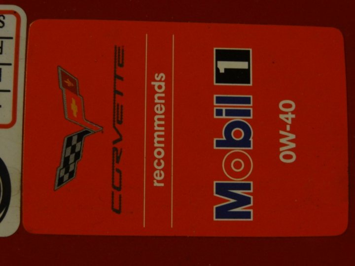 Help out a YANK !! - Page 1 - Corvettes - PistonHeads - The image features a red car care product, possibly a recommendation for oil or fluid. The text on the label reads "CORVETTE," "MOBIL 1 L," "RECOMMENDS," and there's a model number "43-40" mentioned. The label design includes the Corvette logo and some racing checkered flag designs, suggesting this product is associated with high-performance or racing vehicles. The overall style of the image is clean and promotional, with a clear focus on the product and its intended market.