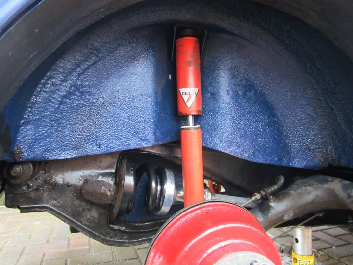 A close up of a person riding a motorcycle - Pistonheads - The image captures the underside of a car, focusing on the exhaust pipe and muffler. A noticeable feature is the red coating of the exhaust pipe, which appears to be rusted or partially corroded. Positioned near the muffler is a yellow and red cylindrical object, possibly a tool or a brake component. The engine is also visible, showing some metallic parts and components that are part of the car's plumbing system and suspension components.