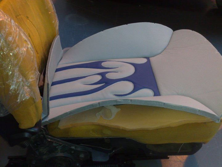 Pistonheads Truck Chevy - The image shows a furniture piece, specifically a seat or a cushion, with its cover partially removed like a painting peeling off a canvas. The cover is predominantly white, adorned with geometric designs in shades of blue and yellow. The underside of the cover reveals a contrasting layer of pale yellow material, hinting at its structure or material properties. This item is placed on a flat surface, possibly a shop floor or storage area, as indicated by the industrial backdrop. The image gives an impression of transition or transformation of the piece, from its dressed state to an exposed, more informative form.