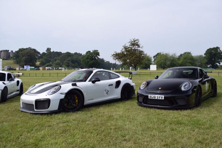 A couple of cars are parked in a field