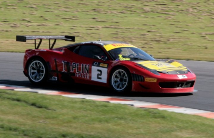 A red and white fire truck sitting on the side of a road - Pistonheads - This image captures a thrilling moment on a race track, featuring a red sports car in full racing gear. The car, adorned with the word "PLUTIN" on its side and bearing the number 2, is caught in the midst of a sharp right turn. A prominent aerodynamic wing on its rear end is indicative of the car's high-speed capabilities. The setting is a dedicated race track with grassy areas and a clear sky overhead, enhancing the excitement of the scene.