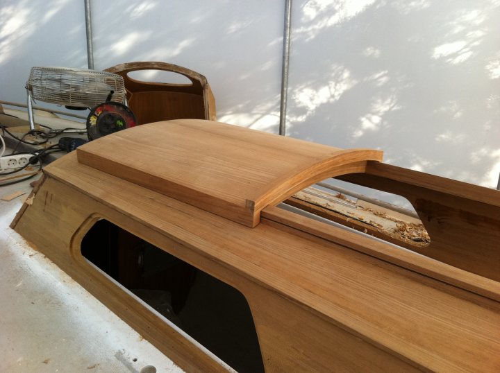 Pistonheads - The image shows a wooden boat build project in progress. The boat in the foreground is the most visible part and is constructed with a wooden hull. Various tools and materials are scattered alongside a wood planer, suggesting an active building process. In the background, a small, unfinished boat can be seen, hinting at a series or multiple boats under construction. The space appears to be an outdoor area, likely a workshop or backyard area.