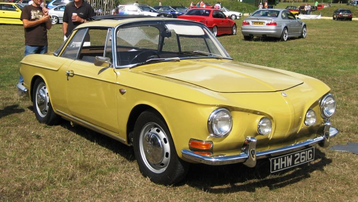 Pistonheads - The image showcases a scene from a classic car show, with the focus on a restored, yellow, classic three-door minivan. The vintage car is parked on a grassy field, surrounded by a variety of other vintage vehicles. The body of the car appears to be well-maintained, embodying the charm and style of a bygone era. In the background, there are several people milling about, likely participants or attendees of the car show, adding a lively atmosphere to the event.