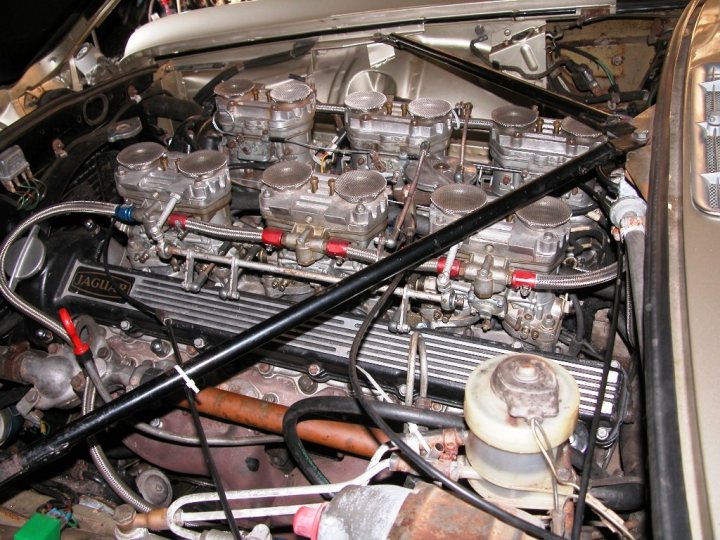 A bunch of items that are on a shelf - Pistonheads - This image shows the interior of a classic car's engine compartment. The engine appears to be a revised air-cooled flat-four unit, with prominent details such as visible gearbox elements and multiple red and blue tubing hoses. The car has engine blanks adorning the engine compartment, and the view is quite detailed, with close-up perspectives of various components, including metal cooling fins and mechanical engine parts. The careful placement of wires and tubes suggest an old-world style of engine assembly. The colors of the tubing and the finishes on the blanks contrast nicely with the metallic highlights of the engine.