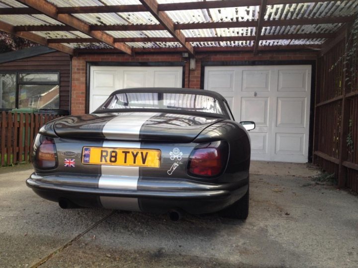 The East Anglia Spotted Thread - Page 212 - East Anglia - PistonHeads - The image shows a black and white motorcycle parked in front of a garage. The motorcycle features a striking black and white color scheme and a license plate that reads "R8 TYV". It's positioned in such a way that the angle of the garage door allows a clear view of the entire vehicle. In the background, there's a wooden fence and a small part of a house is visible, suggesting a residential area.