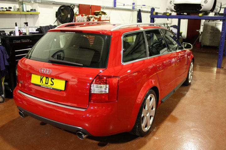 Detailed Avantlots Pistonheads - The image shows a vibrant red Audi car parked inside a garage. The license plate of the car reads "KDS". It reflects the clean environment of the garage, its shiny body gleaming under the lighting. A toolbox and mechanical equipment can be seen in the background, indicating that this is a space for car repair and maintenance. The car seems to be the center of attention, placed prominently in the foreground of the image.