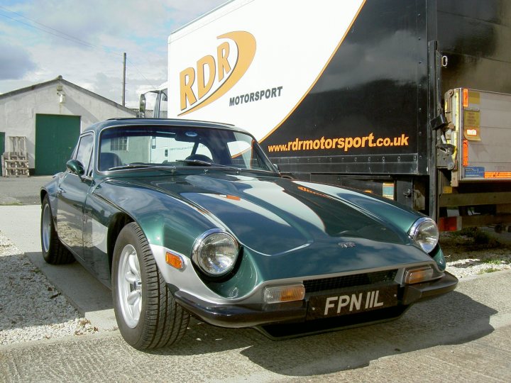 Looking for a Taimar reg FPN 11L - Page 1 - Classics - PistonHeads - The image shows a dark-colored vintage car parked next to a black trailer. The car is positioned at an angle, with the front side slightly visible in the foreground. The license plate on the car reads "FNP III". There is an advertisement in the background featuring a logo with "RD Motorsport" and "RD Motorsport UK" text. The style of the car and the branding suggests the photo was taken before 2000, possibly at a motor-related event.