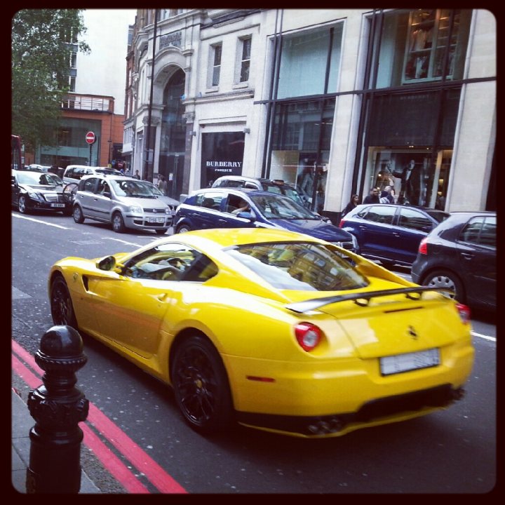 A yellow taxi cab driving down a street - Pistonheads