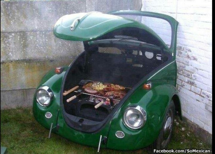 Pictures of decently Modified cars [Vol. 2] - Page 174 - General Gassing - PistonHeads - The image shows a Volkswagen "Poly Wog" fighting van, which serves as a grill. The car is painted green. The grill is open and filled with a red and brown barbecue setup. It appears that the car is parked outdoors, possibly in a driveway or yard, with a child's seat placed in the front, suggesting a playful or family-oriented environment.