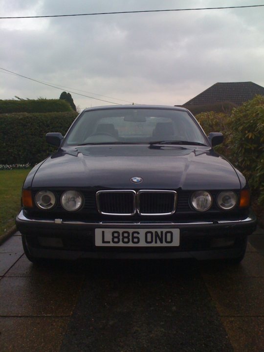 Pistonheads Shed Week - The image features a black BMW coupe parked on a sloping driveway. The car is facing the camera and is positioned on a brick pattern which indicates a parking area. The license plate of the car is clearly visible and reads "L88 ONO". The surrounding environment is residential, with green lawns and what appears to be hedges in the background, suggesting a suburban setting. The sky is overcast, indicating a cloudy day. The BMW badge is prominently displayed on the license plate, and the design of the car is sleek and modern.